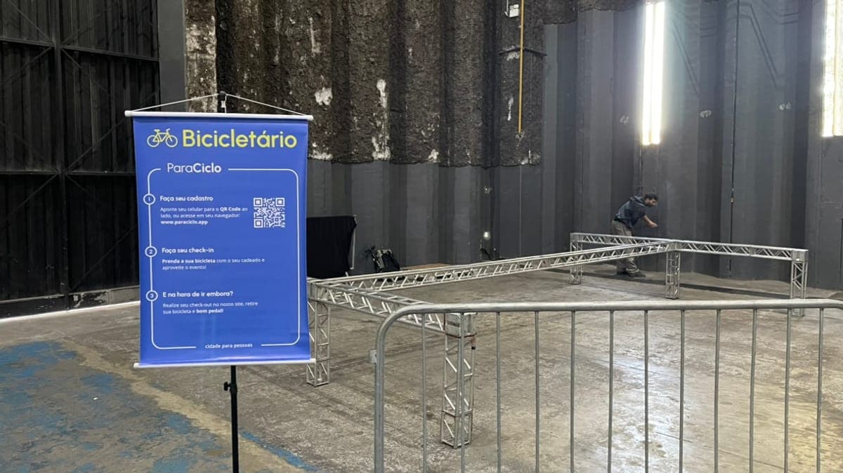 Banner do bicicletário ParaCiclo em um evento, com bicicletas ao fundo